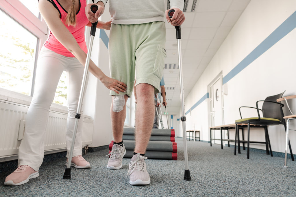 People in rehabilitation learning how to walk with crutches after having had a mva